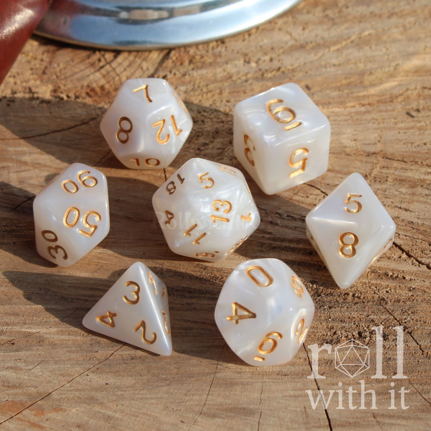 white shot of 7 white dnd dice on a wooden surface