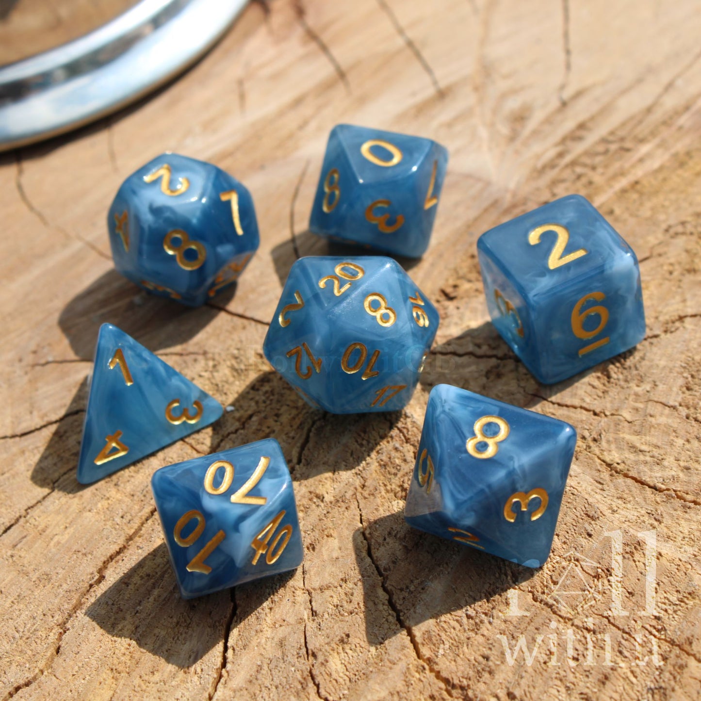 Set of blue polyhedral dice with gold numbers on a wooden surface
