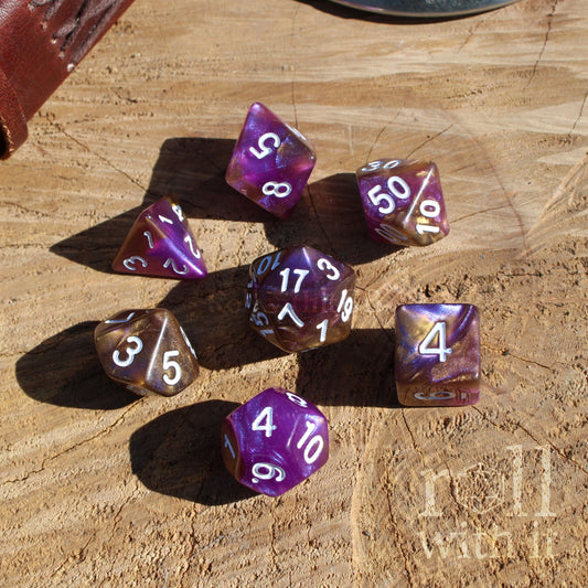 Top down of 7 purple luxury polyhedral dice resin set on a wooden surface