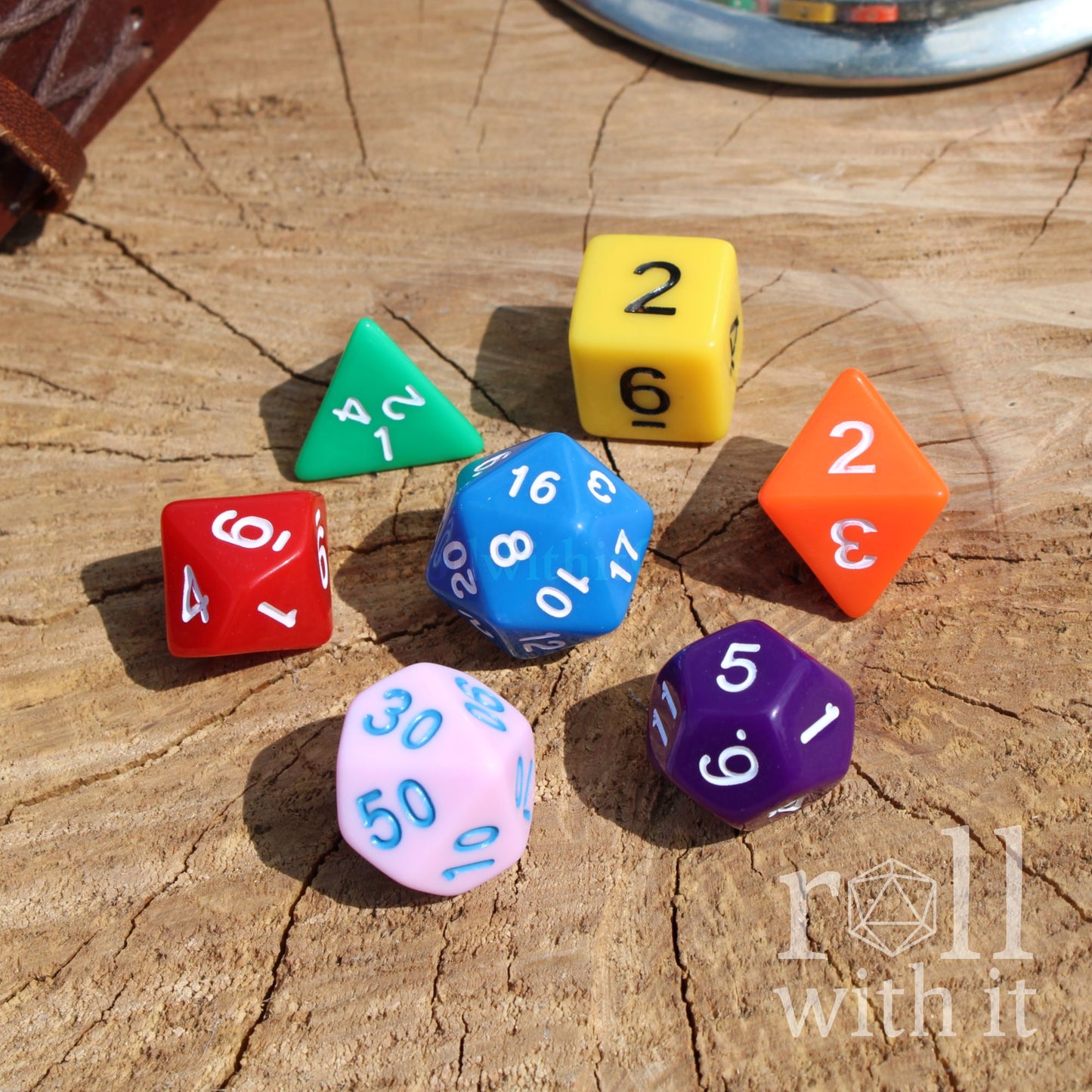 Colorful polyhedral dungeons and dragons dice on a wooden surface with 'roll with it' text.