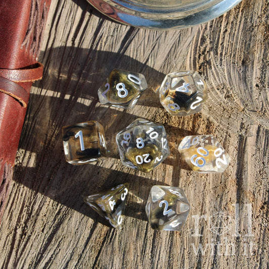 Set of clear dice golden black glitter with black numbers on a wooden surface