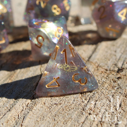 Close up of glitter filled dungeons and dragons polyhedral dice with golden cog gear inside on a wooden surface
