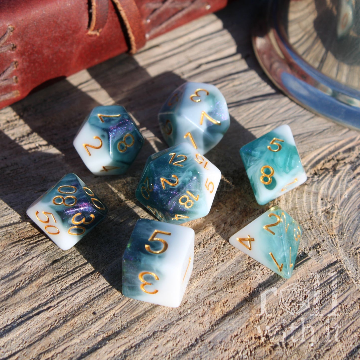 Set of 7 deep blue and white dice with gold numbers on a wooden surface