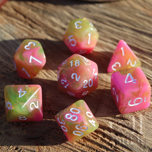 Set of colorful soft pink olive green cute polyhedral dice on a wooden surface