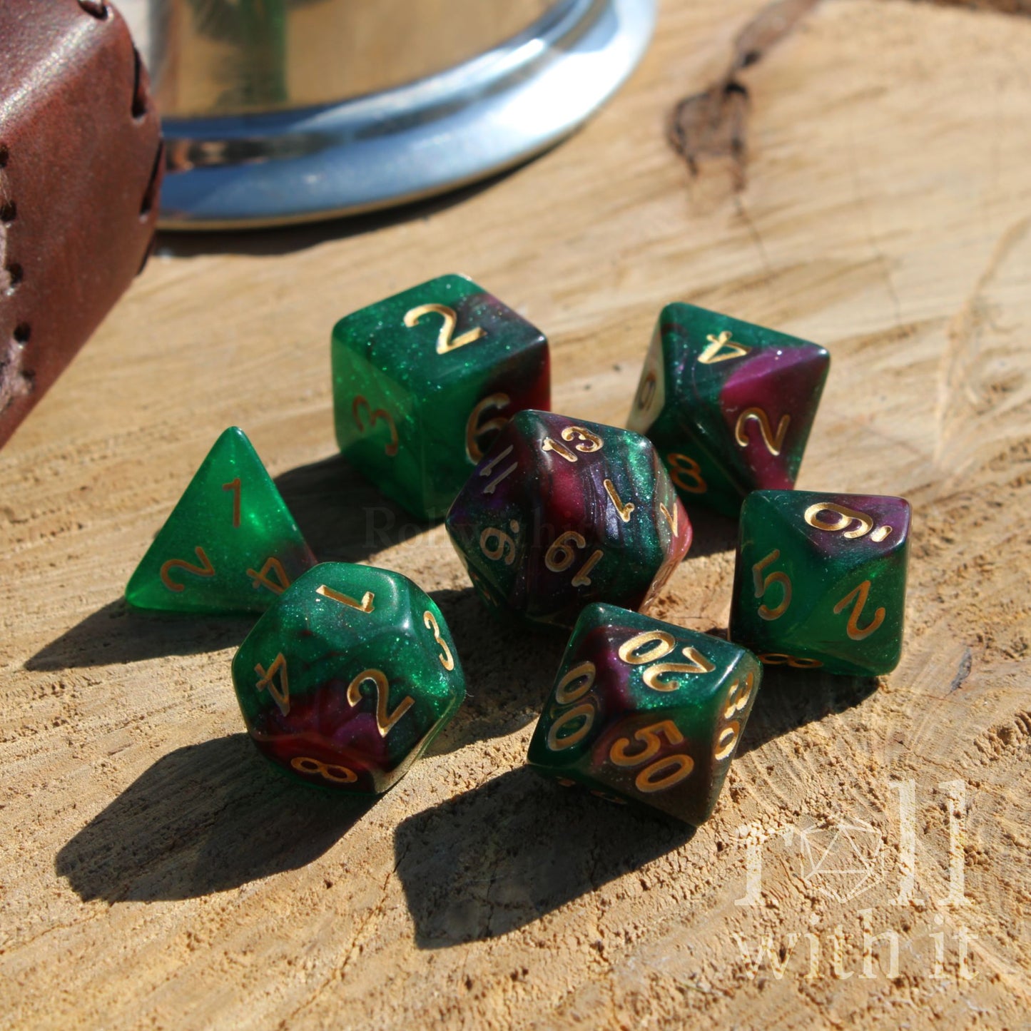 Set of green and purple playing polyhedral dice on a wooden surface