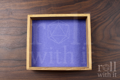 Solid oak DnD roleplaying dice throwing tray with a violet purple felt base, on a walnut worktop.