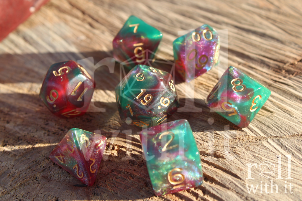 Set of teal and pink shimmering  polyhedral DnD dice on a wooden log.