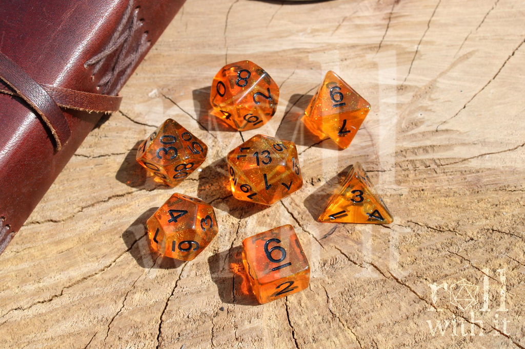 Set of orange Tangerine Sun Kiss polyhedral dice with black numbers on a wooden surface