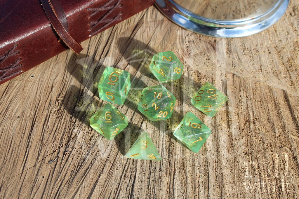 Set of 7 TTRPG polyhedral dice in green with shimmering on a wooden surface