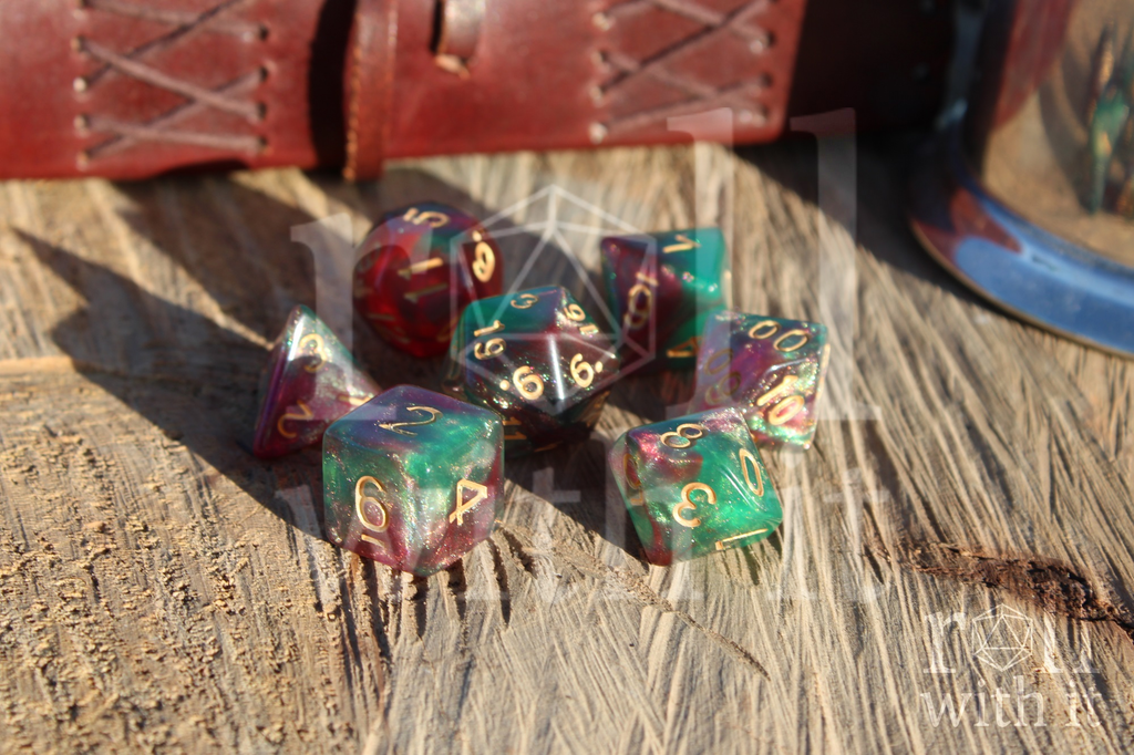 Set of multicoloured polyhedral roleplaying dice on a wooden surface with a leather journal in the background.