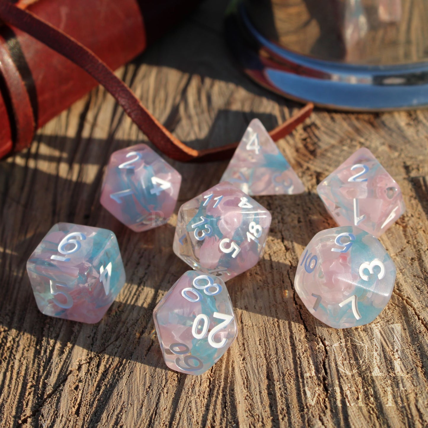 7 Pink blue pale resin roleplaying gamers gift dice with white numbers on a wooden surface