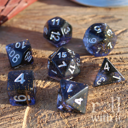 Set of dark clear blue polyhedral dice with silver numbres and golden stars on a wooden surface