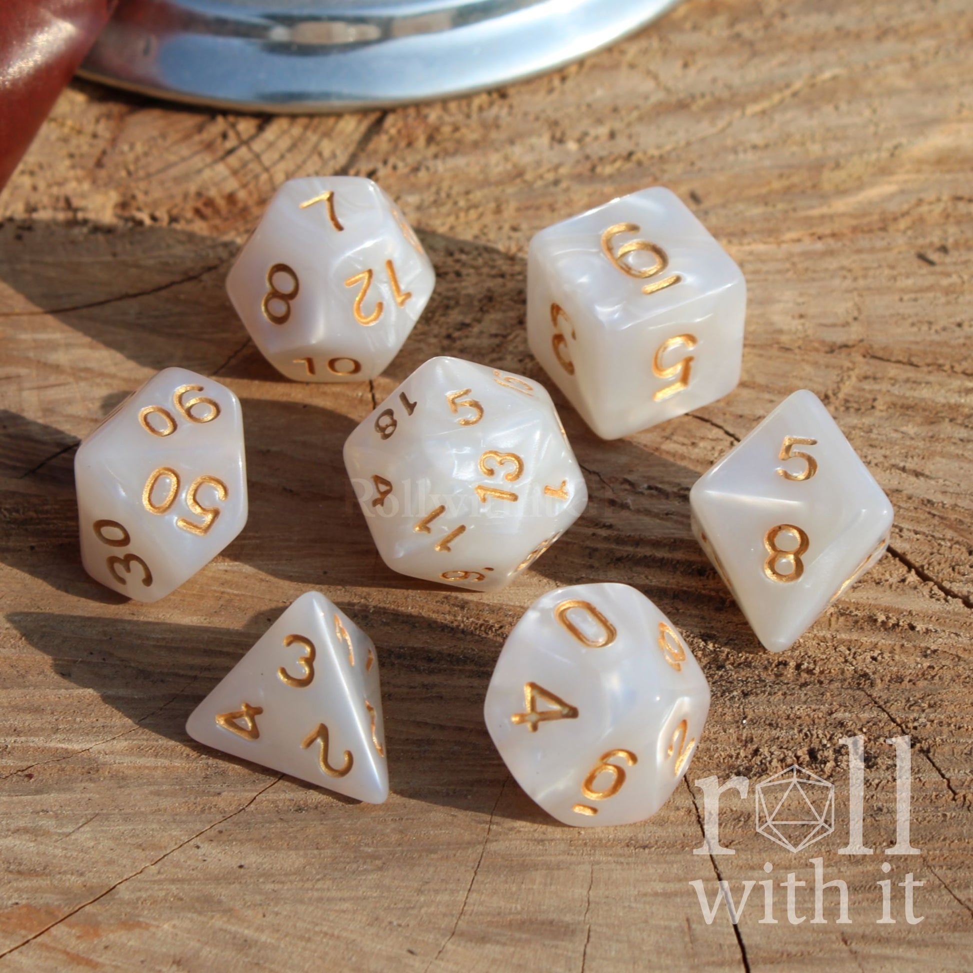 white shot of 7 white dnd dice on a wooden surface