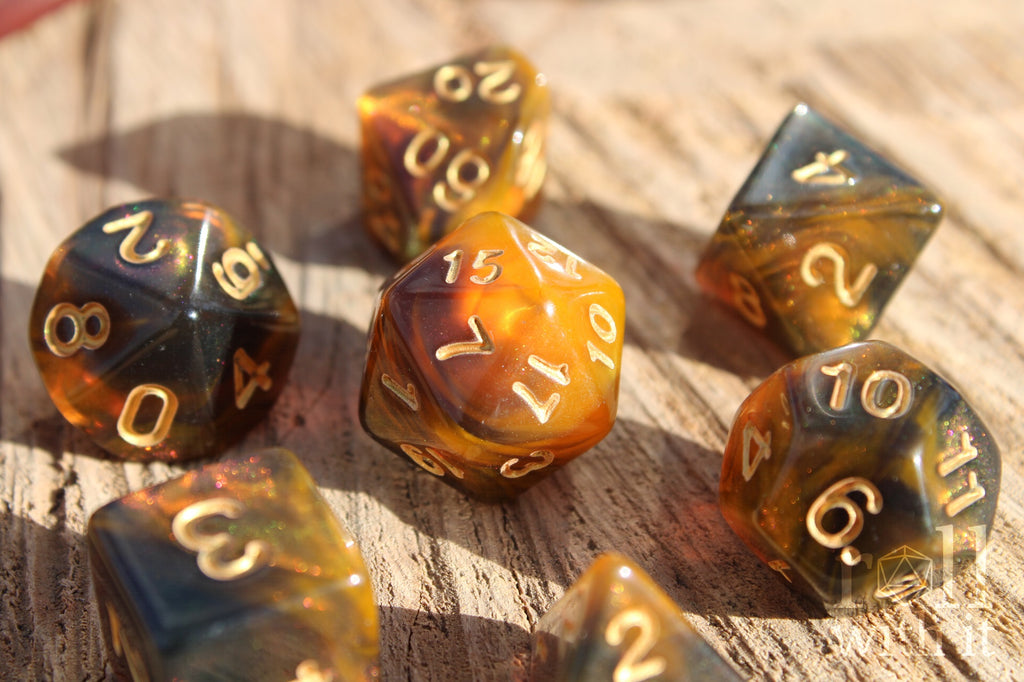 Set of 7 smoky amber and orange swirling glittery polyhedral roleplaying dice on a wooden surface.