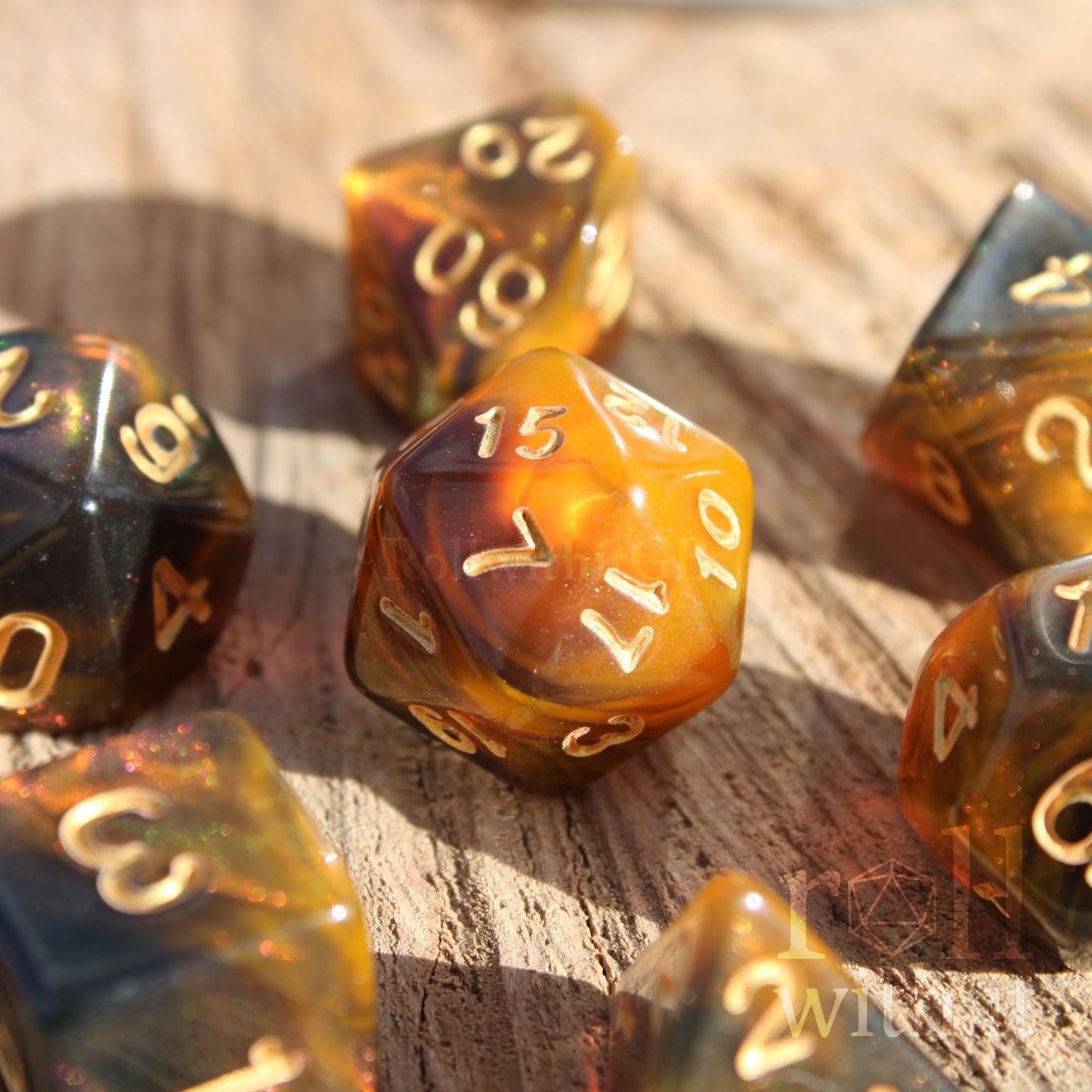 Set of amber honey gold brown polyhedral dice with gold numbers on a wooden surface