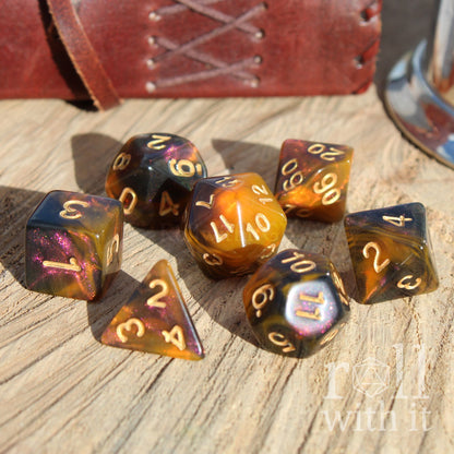 Set of amber honey polyhedral dice on a wooden surface with 'roll with it' text.