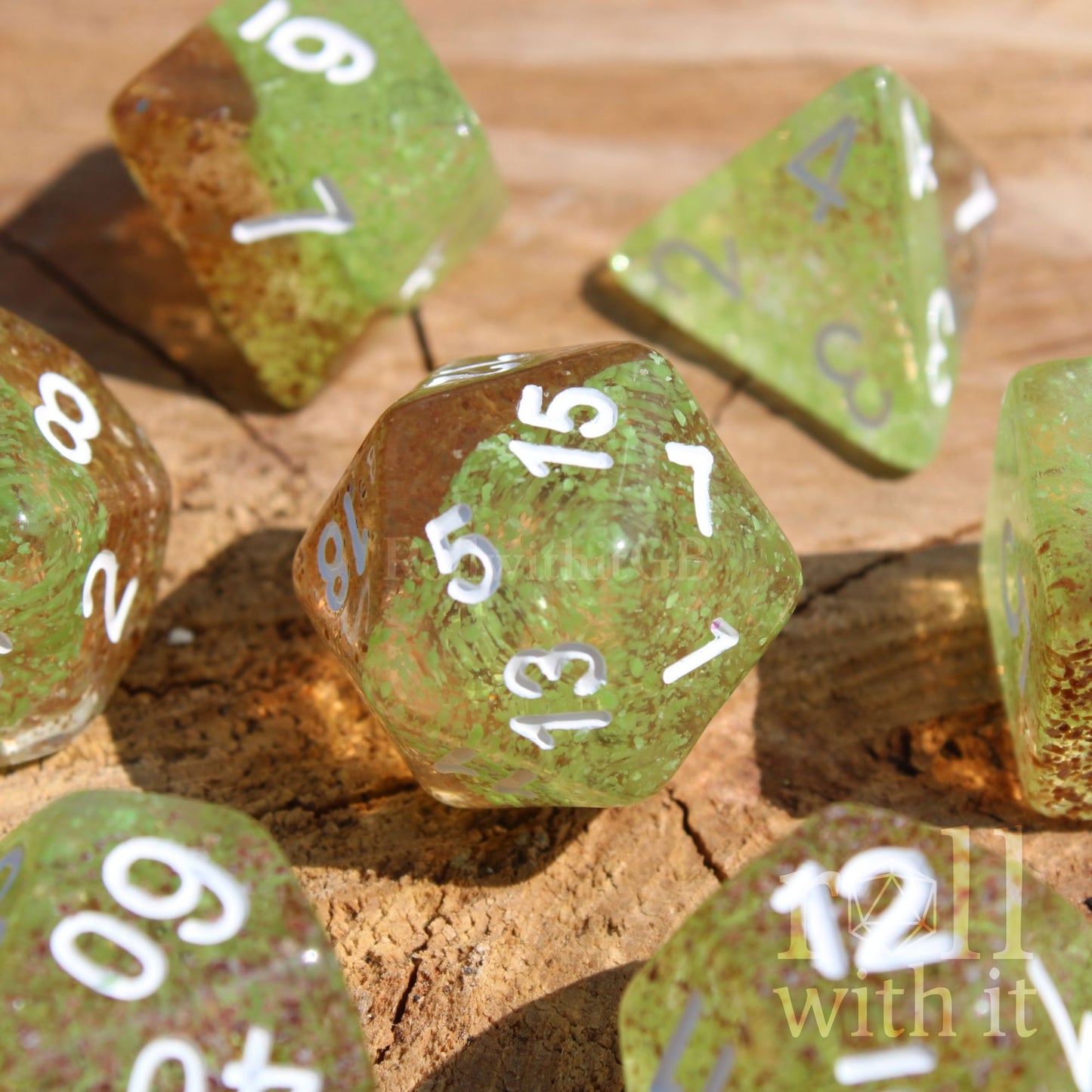 Apple green and ginger brown speckled polyhedral DND dice with white numbers sat on a wooden surface