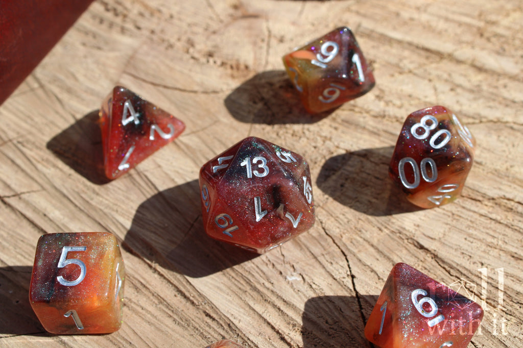 Set of glittery burnt orange polyhedral dice with silver numbers, sat on a wooden oak base.