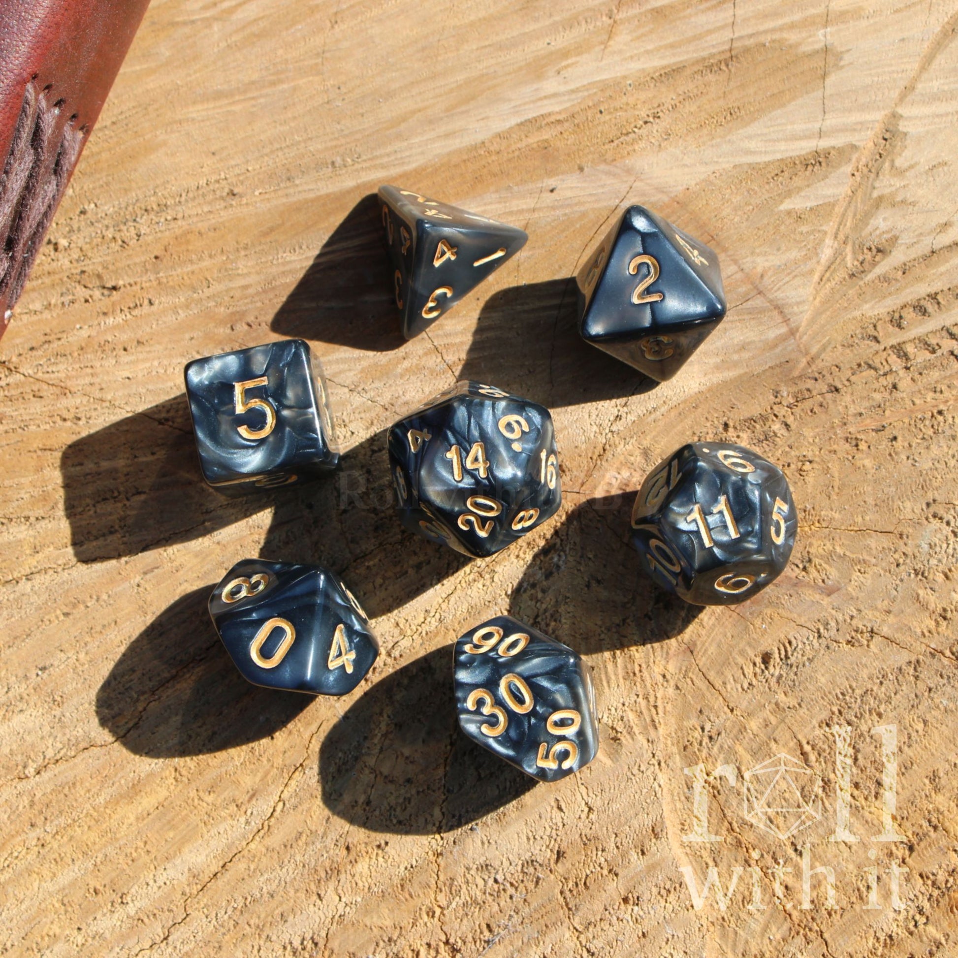 Set of black shiny pearl dice on wooden surface