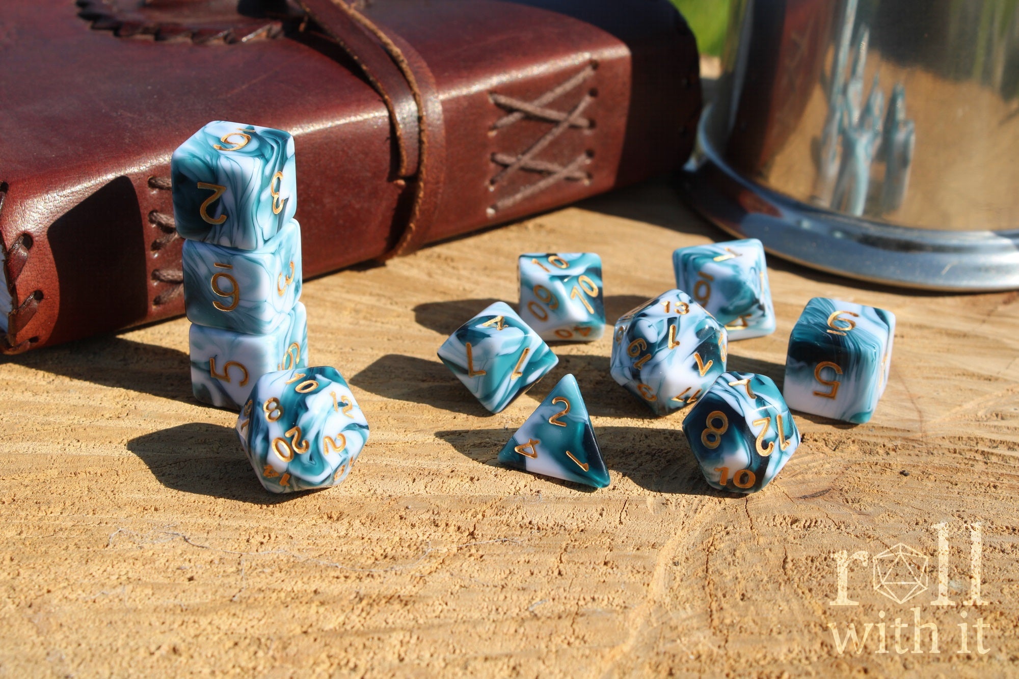 Set of white and blue swirling polyhedral roleplaying dice with gold numbers on a wooden surface