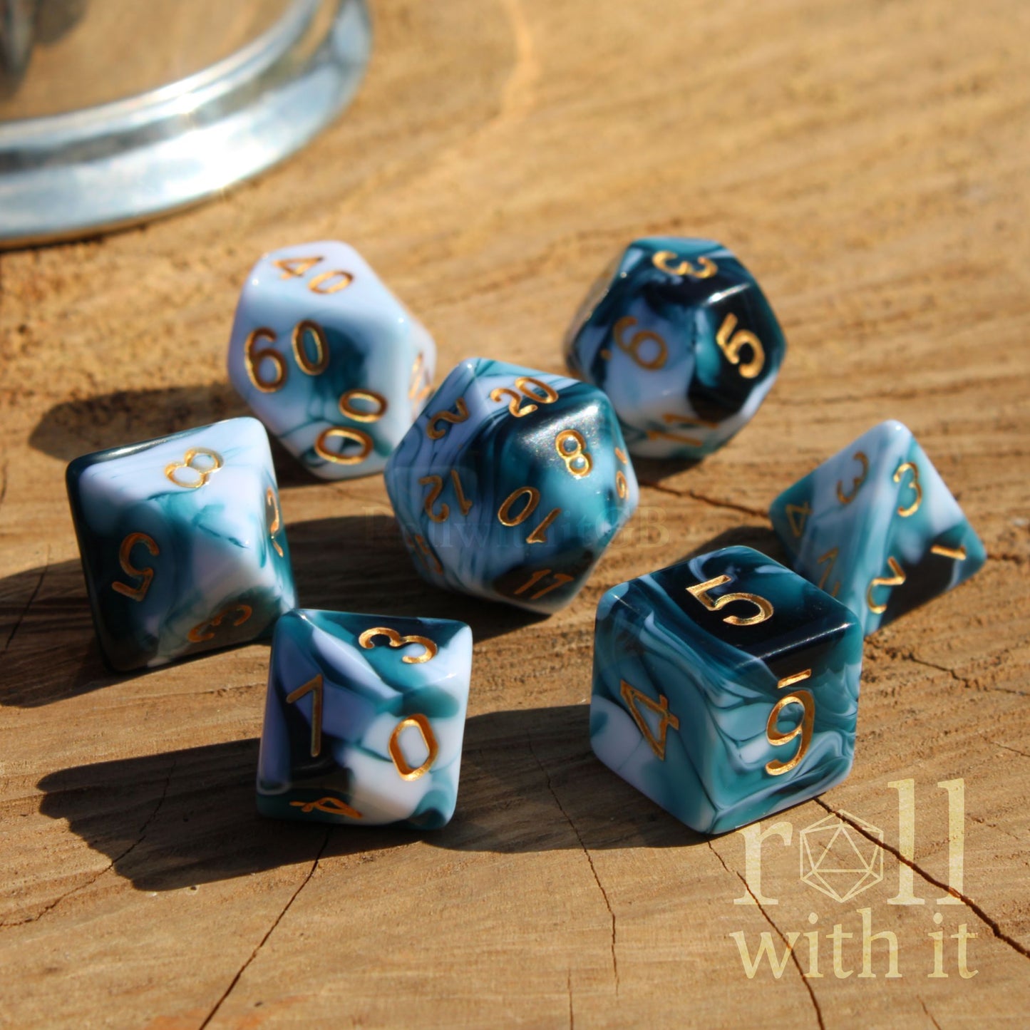 Set of polyhedral dice with blue and white marbled pattern on a wooden surface