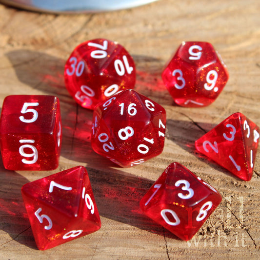 Set of 7 bright glittery scarlet red dice with white numbers on a wooden surface