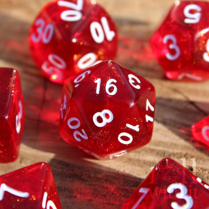 Scarlet red glittery polyhedral roleplaying dice with white numbers on a surface