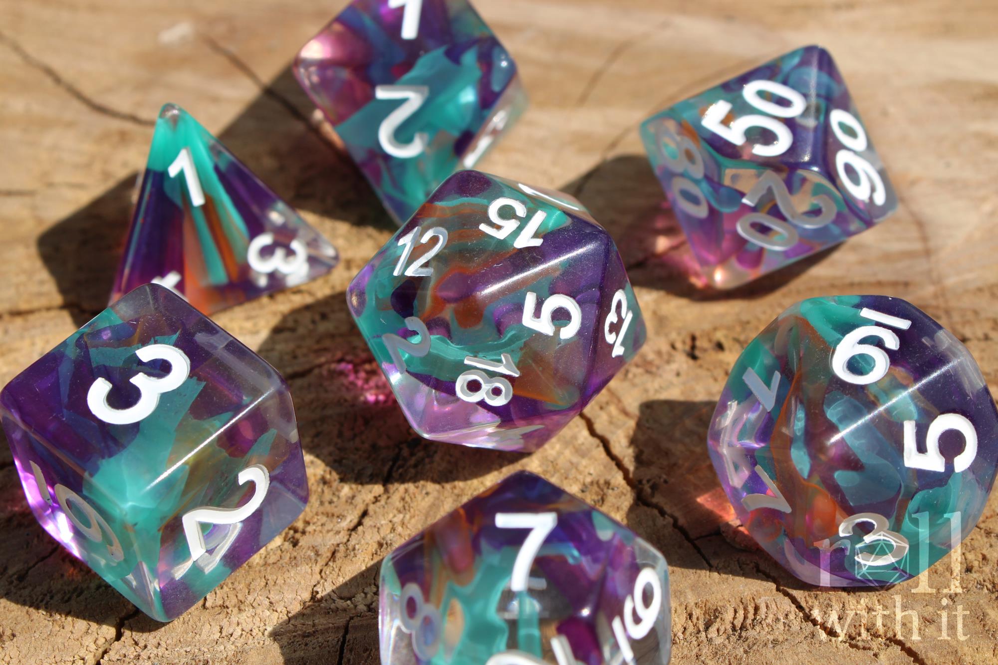 Set of 7 colourful aquamarine blue, lilac and ginger toned multicoloured polyhedral DND roleplaying dice with white numbers on a wooden surface