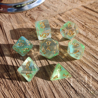 Set of green clear cute elf elven dice with gold numbers on a wooden surface