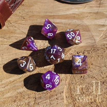 Top down of 7 purple luxury polyhedral dice resin set on a wooden surface
