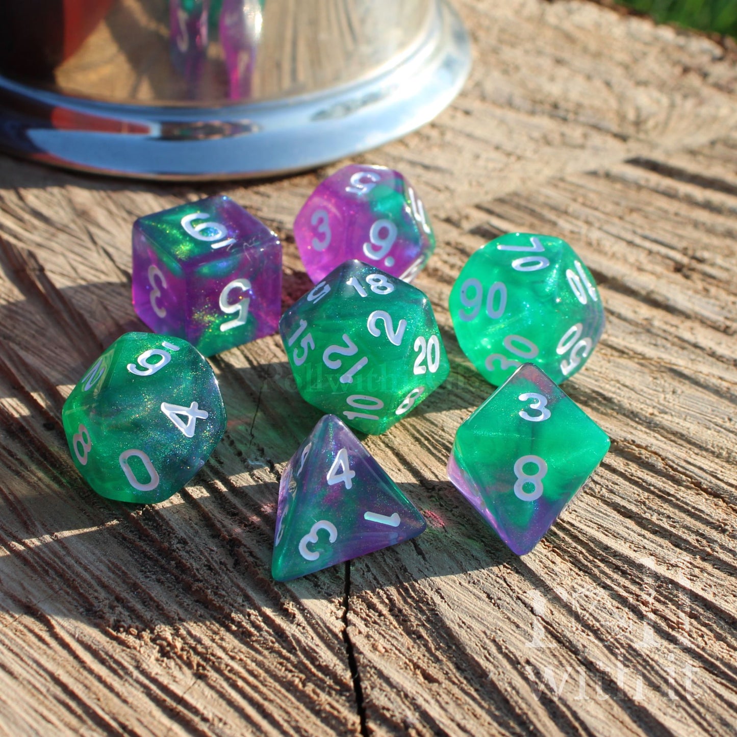 Set of green and purple polyhedral dice on a wooden surface