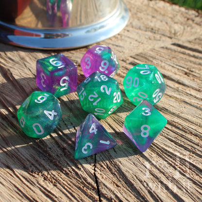 Set of green and purple polyhedral dice on a wooden surface