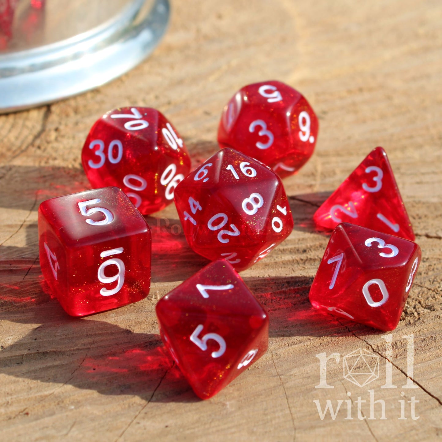 7 red dice with white numbers on a wooden surface, featuring the 'roll with it' logo.