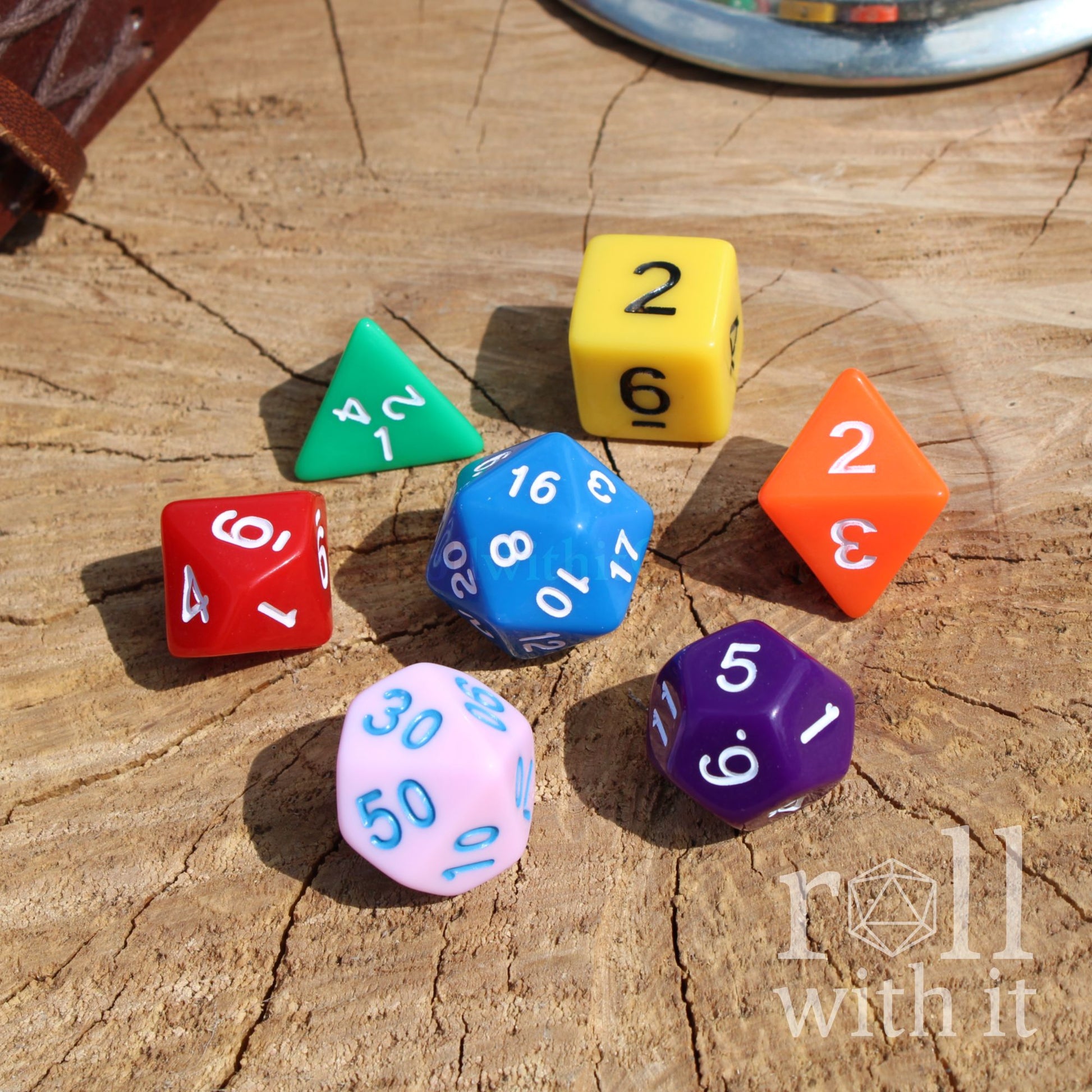 Colorful polyhedral dungeons and dragons dice on a wooden surface with 'roll with it' text.