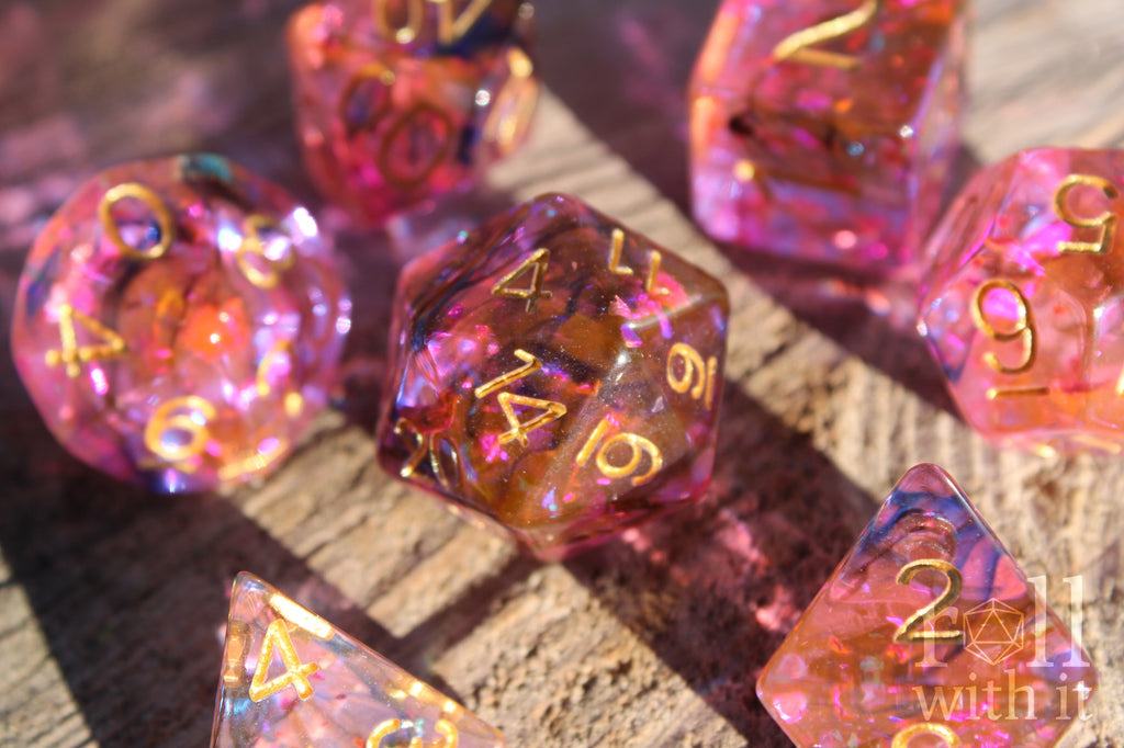 Set of colourful purple and swirling black and orange polyhedral dice on a wooden surface
