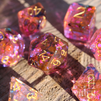 Set of colourful purple and swirling black and orange polyhedral dice on a wooden surface