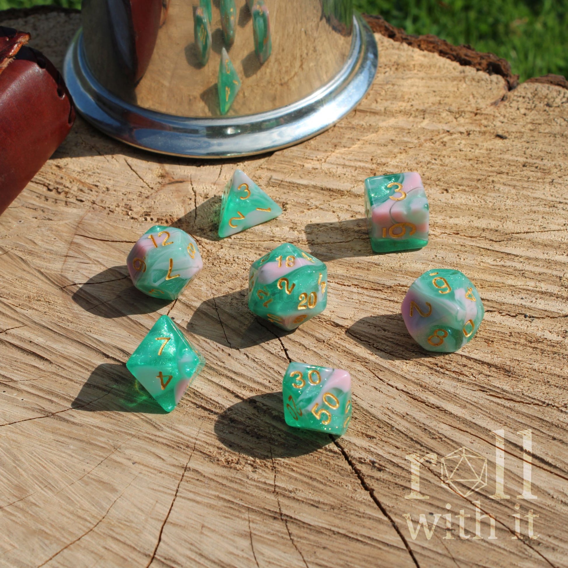 Set of colorful teal bluepolyhedral dice on a wooden surface.