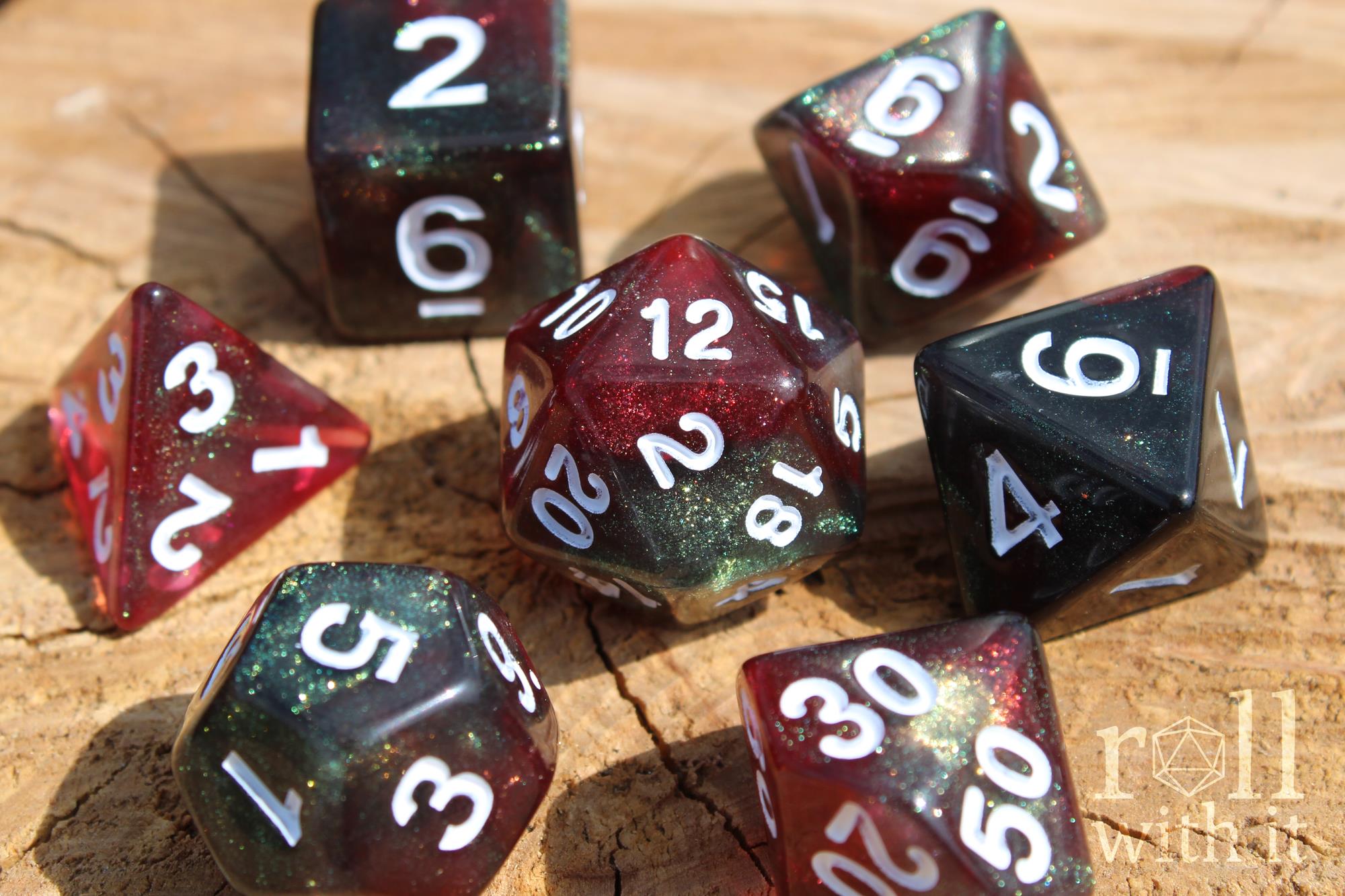 Set of glittery and star like black and red polyhedral dice with a green shimmer on a wooden surface