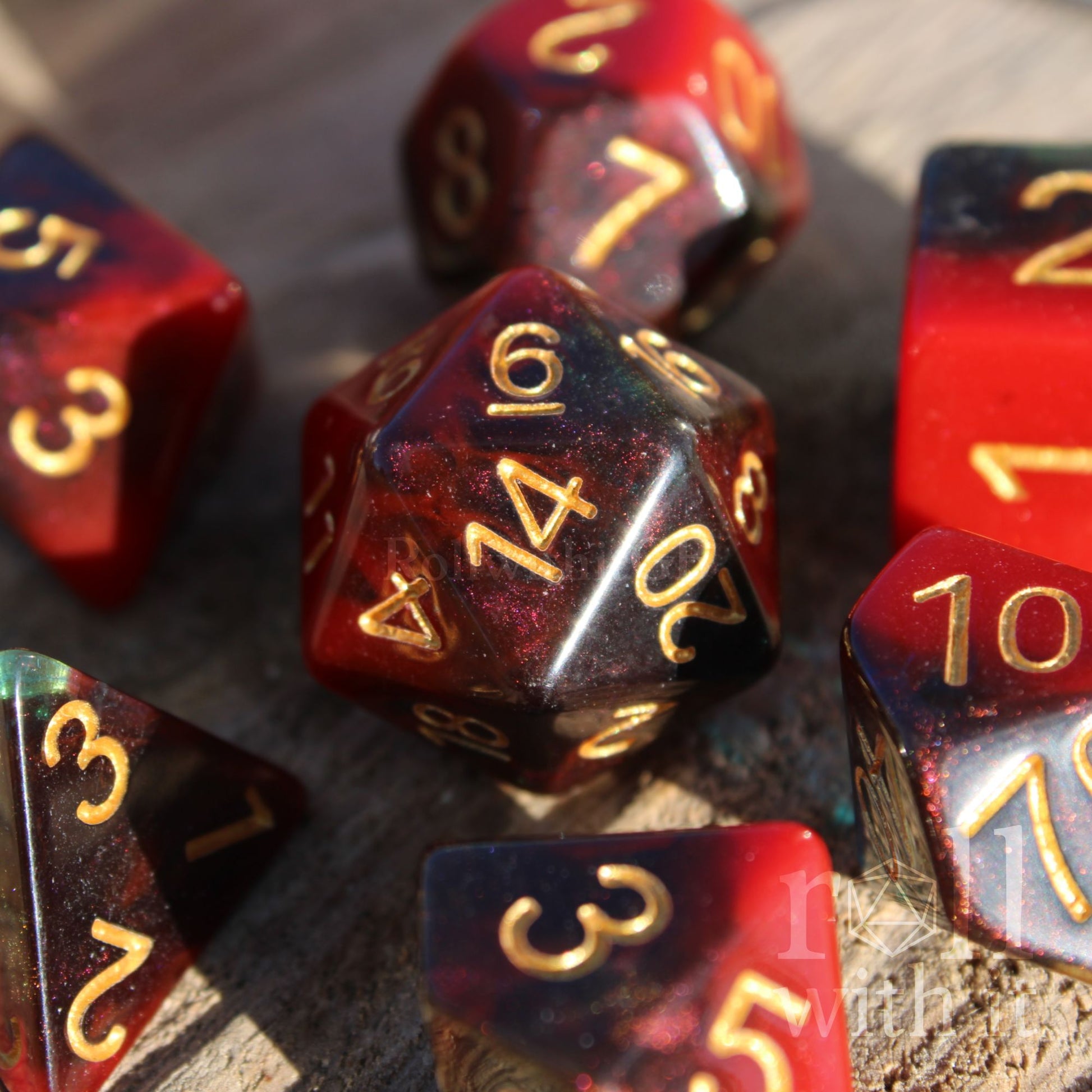 Set of colourful red and deep blue glittery polyhedral dice with gold numbers on a wooden surface