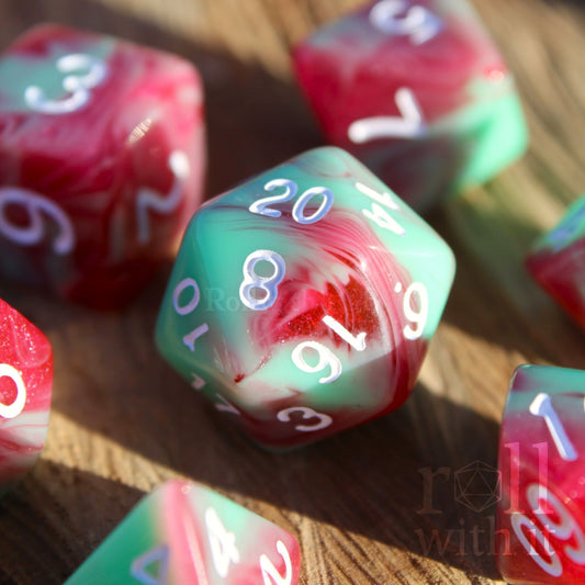 Set of glittery red and pastel green polyhedral roleplaying dice on a wooden surface