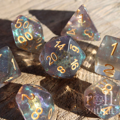 Set of iridescent glittery and starry roleplaying dice with gold numbers and golden cogs inside on a wooden surface
