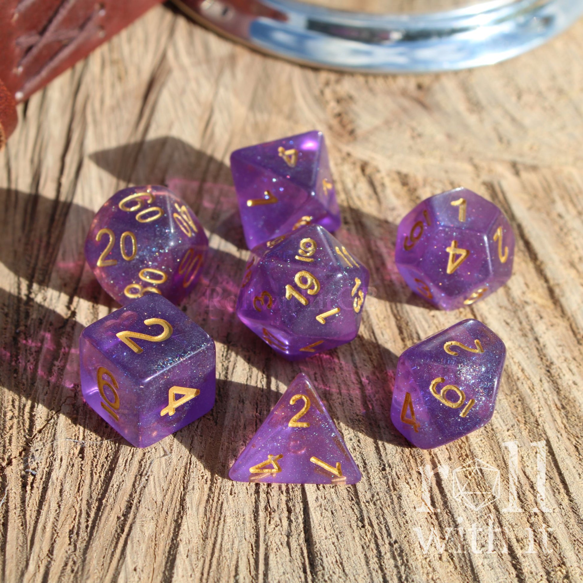 Purple polyhedral dice set with gold numbers on a wooden surface