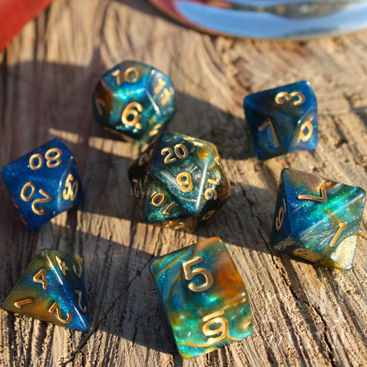 Set of glittery mixed blue, green, and gold polyhedral roleplaying dice on a wooden surface