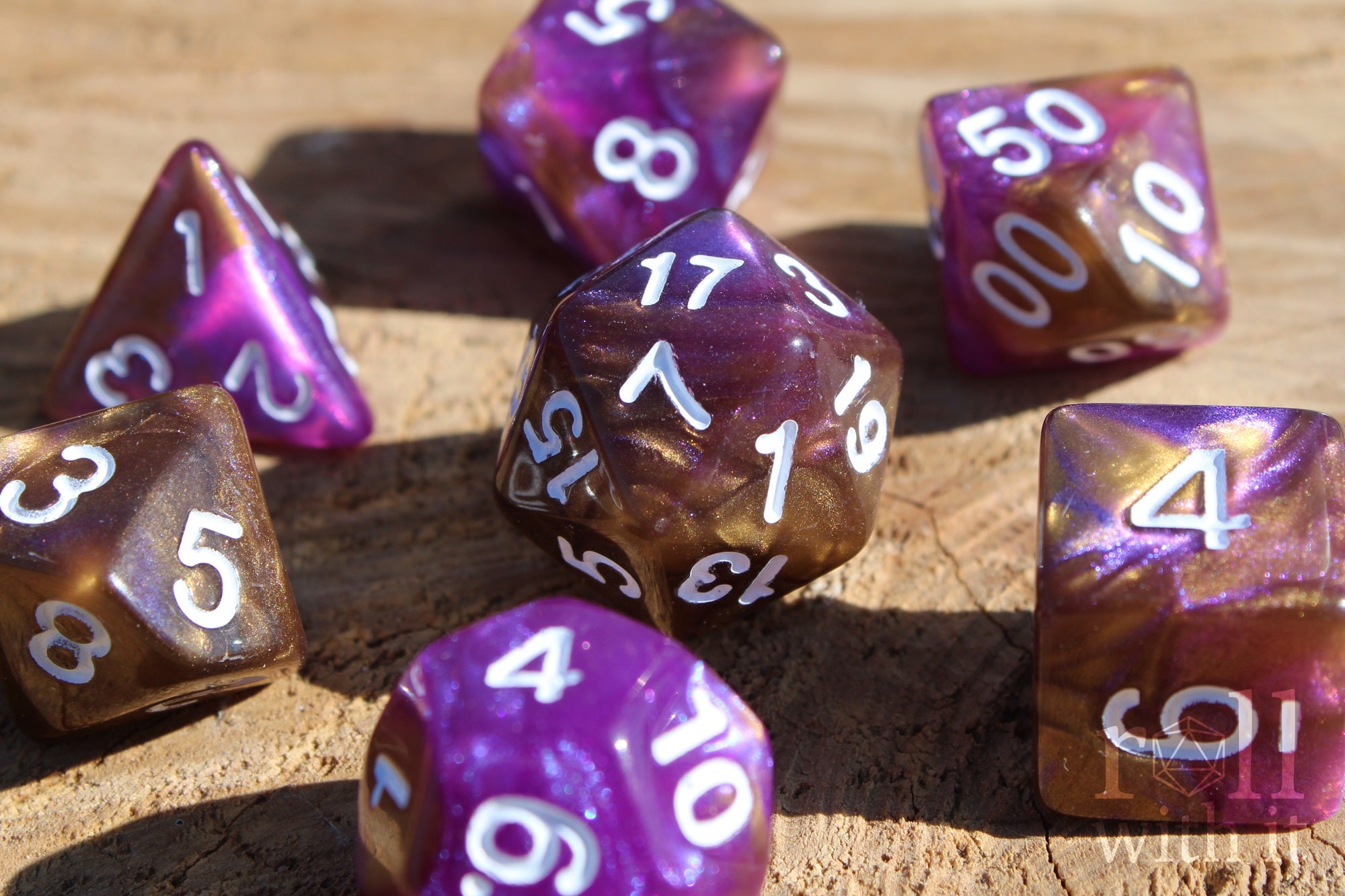 Purple and gold polyhedral roleplaying dice with white numbers on a wooden surface