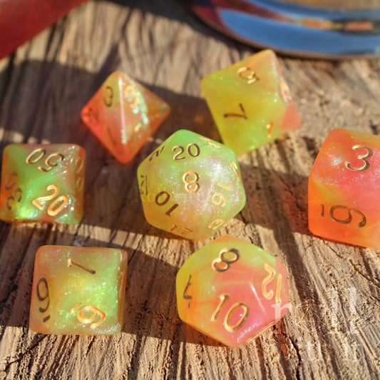 Set of colourful glittery light green and peachy pink polyhedral dice on a wooden surface