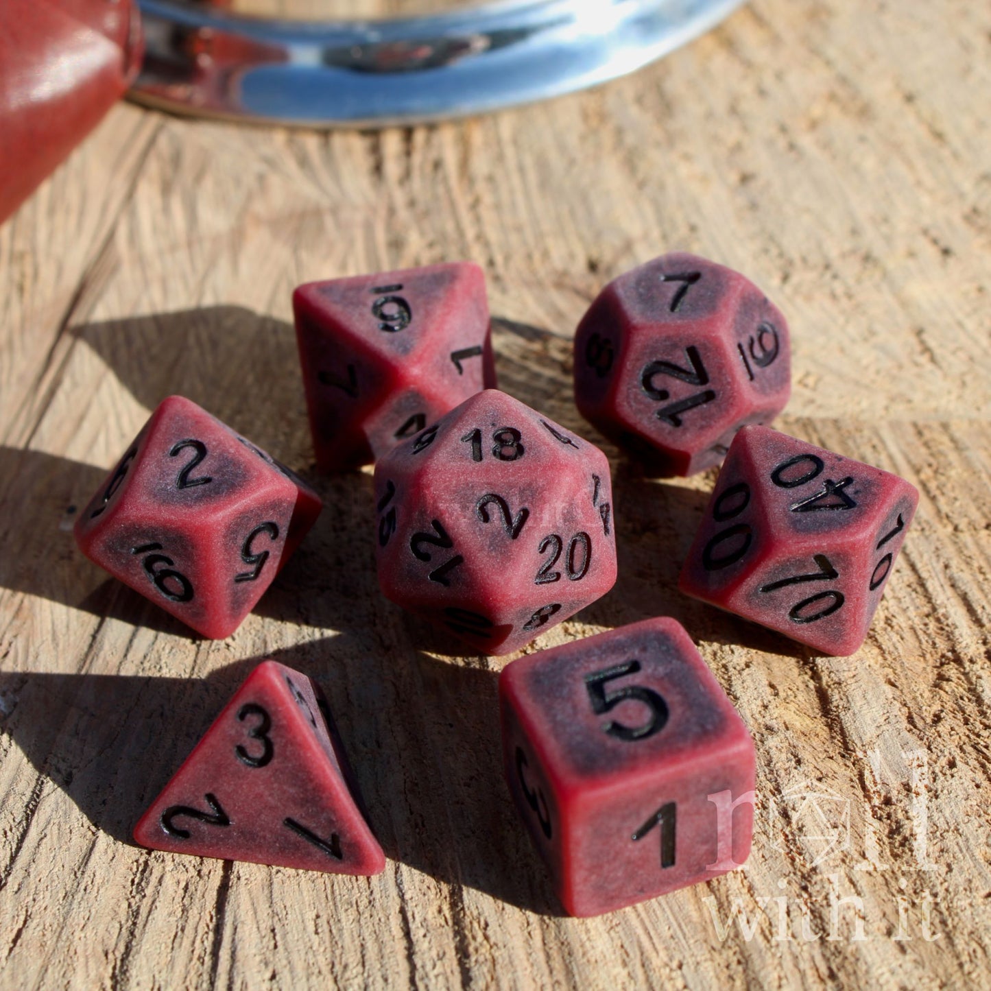 Red matte black numbers polyhedral dice set on a wooden surface