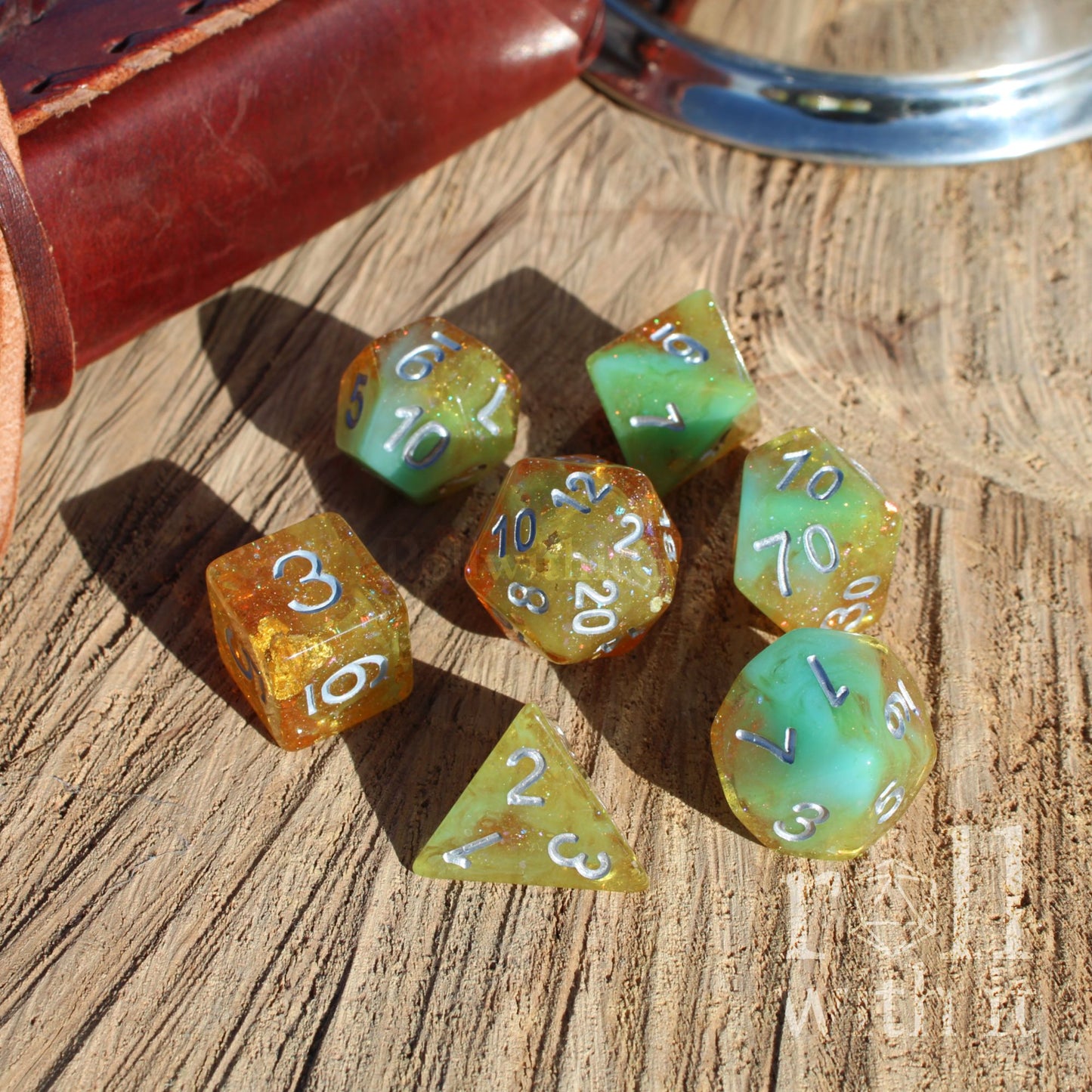 Set of colorful gold foil silver numbers polyhedral dice on a wooden surface
