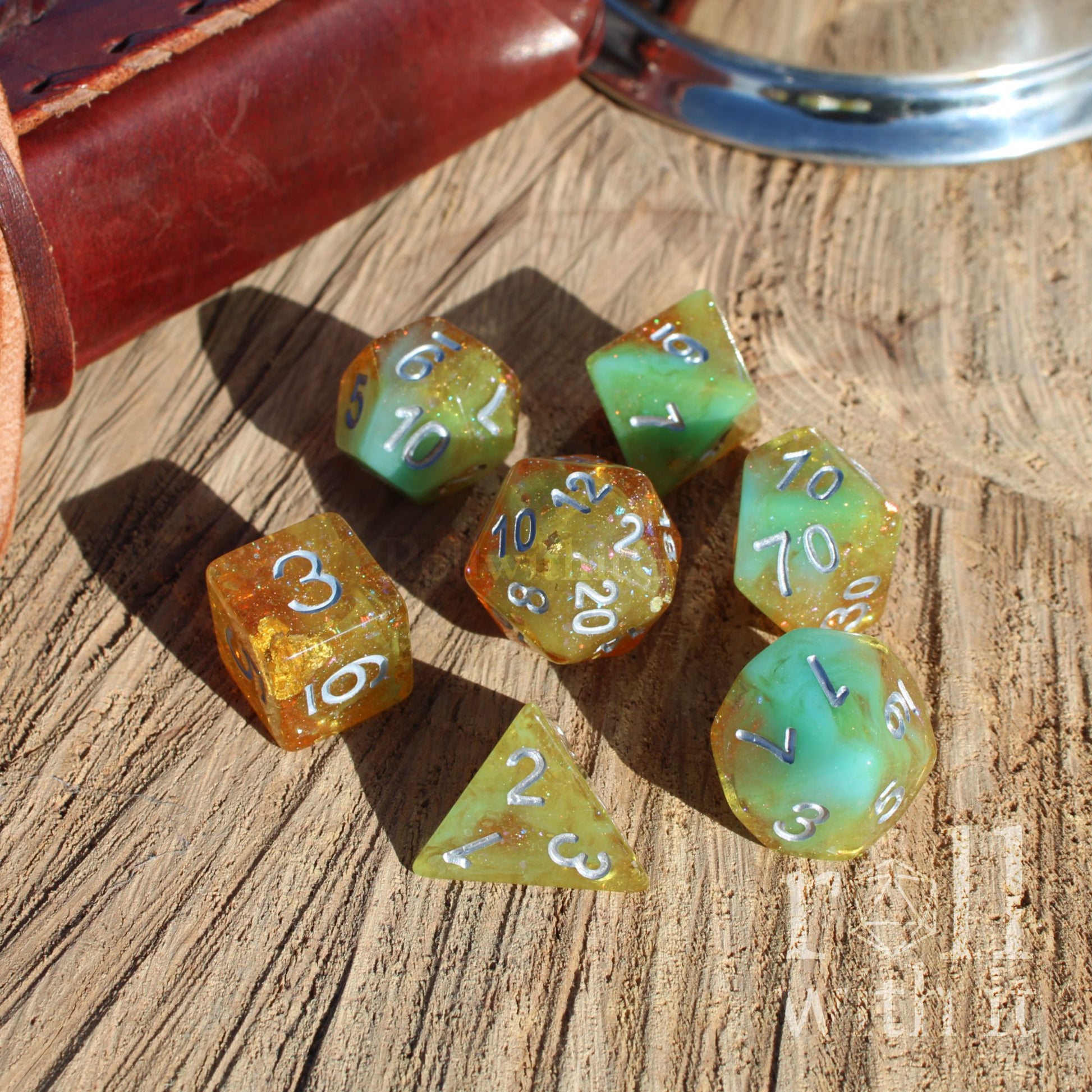 Set of colorful gold foil silver numbers polyhedral dice on a wooden surface
