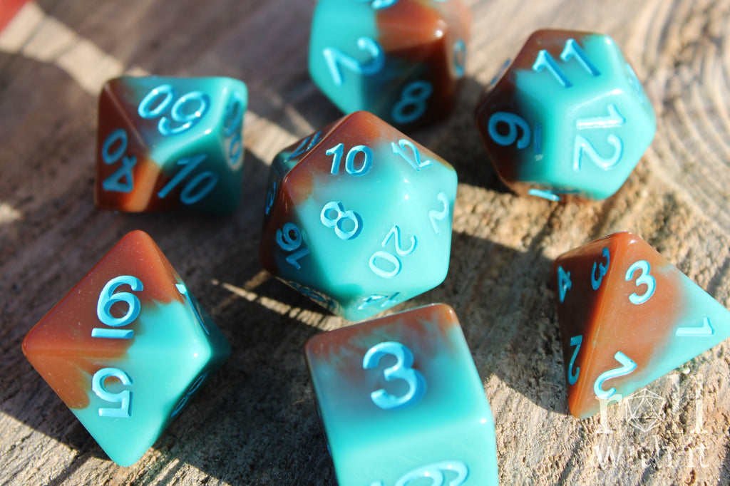 Set of turquoise blue and chocolate brown polyhedral roleplaying dice on a wooden surface