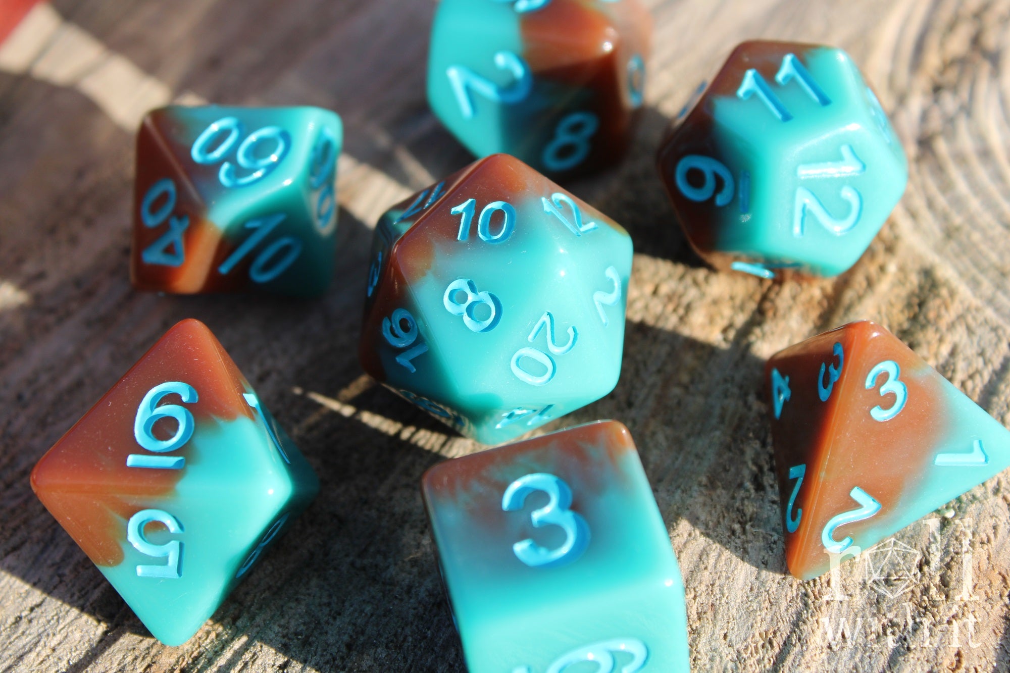 Set of turquoise blue and chocolate brown polyhedral roleplaying dice on a wooden surface